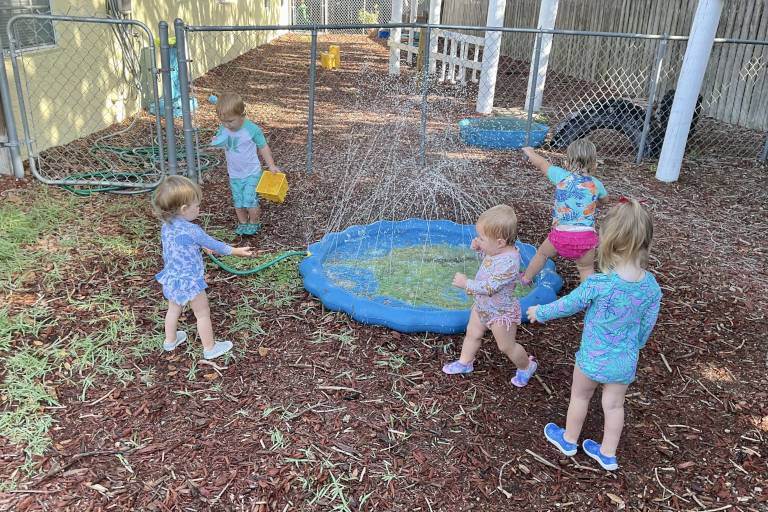 toddlers playing in the sprinklers